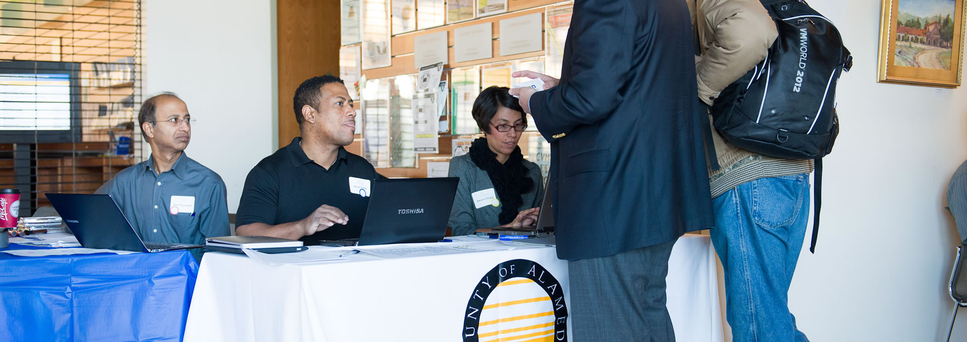 Photo of Alameda County employees registering hackathon participants.