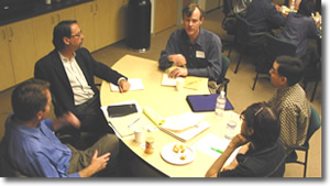 Photo of a group of people meeting around a table.