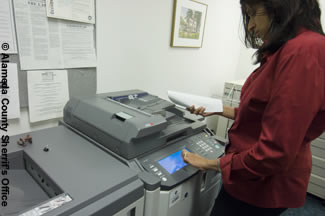 Photo shows a female employee using a copy machine.