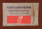 Photo shows a brown-colored trogo trap with a warning to not disturb the trap.