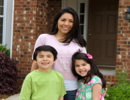 Hispanic mom, son and daughter in front of home