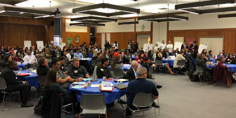 Photo of audience watching presentations.