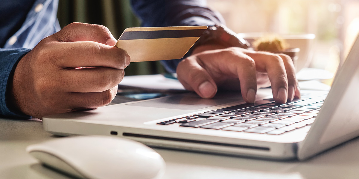 Close up of person entering credit card info on laptop