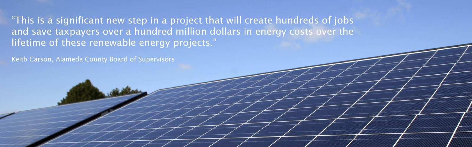 A construction worker posing in front of solar panels